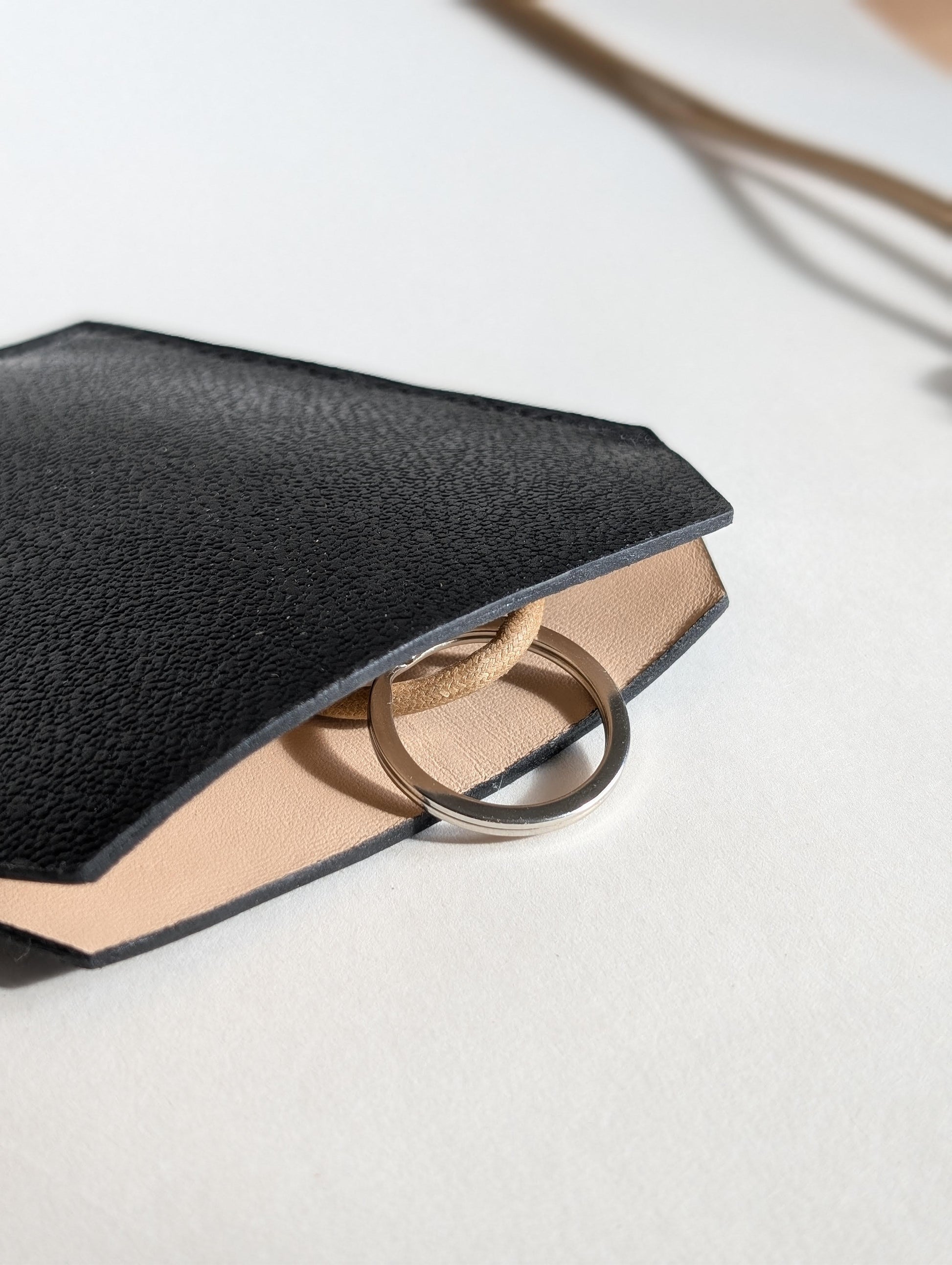 Stylish black leather key case showcasing high-quality, durable design with elegant curves for easy access to keys.